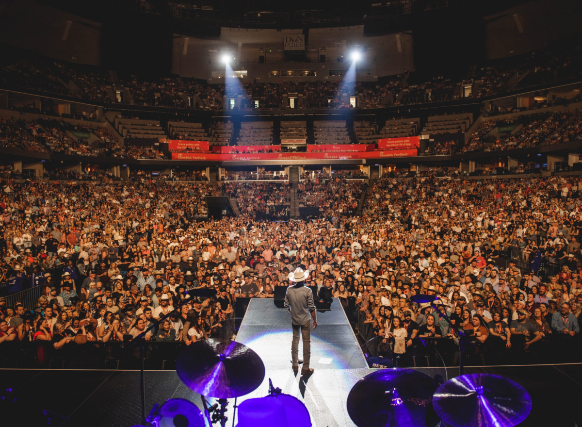 Justin Moore on stage overlooking crowd.